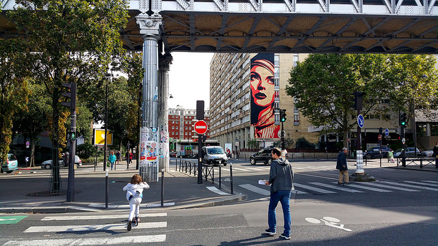 Street Art Wall Mural of Franck Shepard Fairey called Révolution in a large urban landscape.
